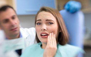 Woman in pain holding cheek