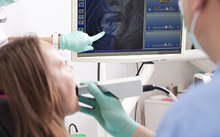 Dentist and patient looking at intraoral photos