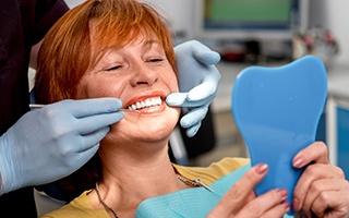 Senior woman looking at smile in mirror